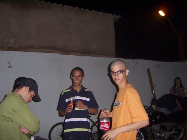 Marco Gomes com 2 amigos numa festa de quinta. Garrafa de Coca-Cola na mão.