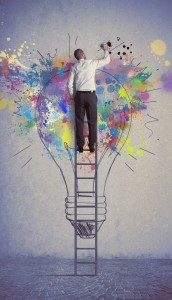 Homem no topo de uma escada vertical, pintando uma lâmpada, o símbolo de "idéia".