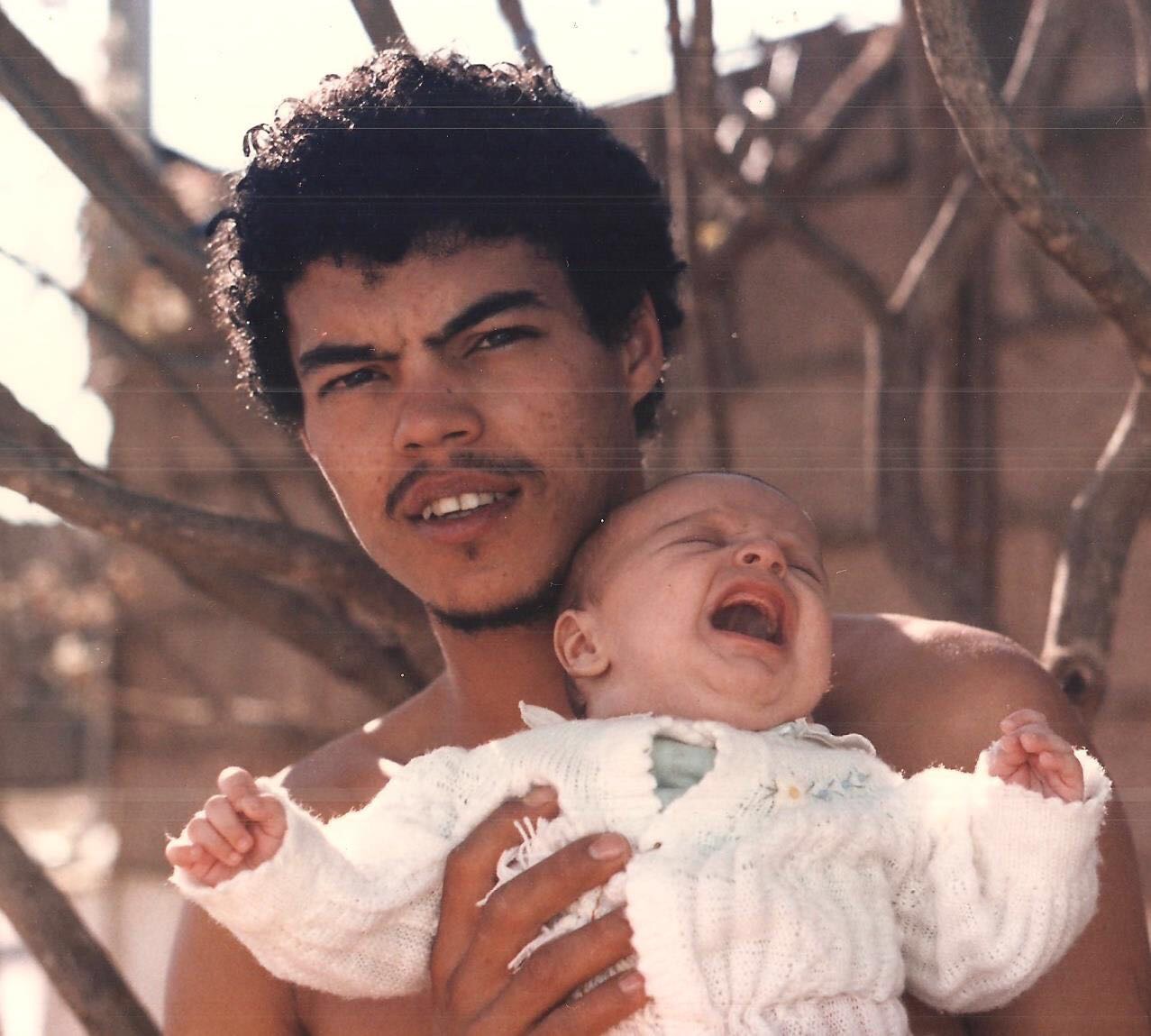 Wilian Gomes aos 21 anos e Marco Gomes, bebê, no colo.