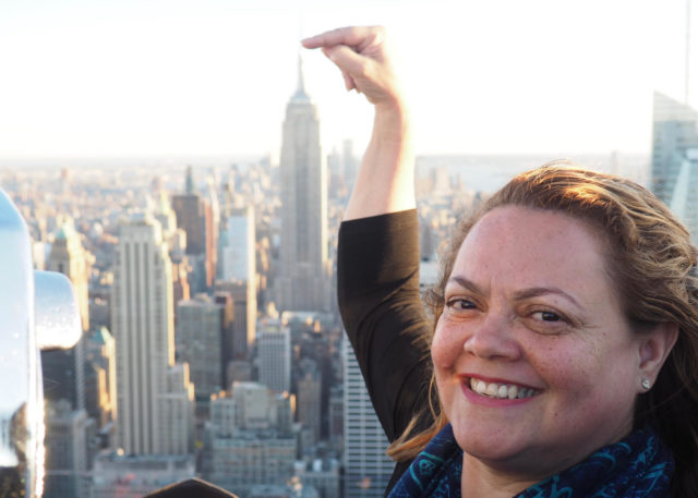 Marisol Gomes aponta o Empire State Building, icônico edifício em Nova York.