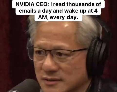na imagem, o CEO da nvidia aparece em close, sentado diante de um microfone de estúdio durante uma entrevista. ele usa óculos finos, jaqueta de couro preta e fones de ouvido grandes. a iluminação destaca o rosto e os cabelos grisalhos. no topo, um texto diz que ele lê milhares de emails por dia e acorda às quatro da manhã. o clima é de conversa séria, típica de podcasts de longo formato.