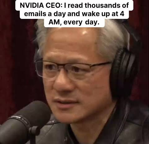na imagem, o CEO da nvidia aparece em close, sentado diante de um microfone de estúdio durante uma entrevista. ele usa óculos finos, jaqueta de couro preta e fones de ouvido grandes. a iluminação destaca o rosto e os cabelos grisalhos. no topo, um texto diz que ele lê milhares de emails por dia e acorda às quatro da manhã. o clima é de conversa séria, típica de podcasts de longo formato.